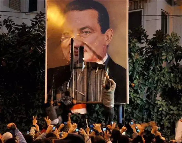 مصريون يمزقون صورة الرئيس الأسبق مبارك خلال ثورة 25 يناير 2011