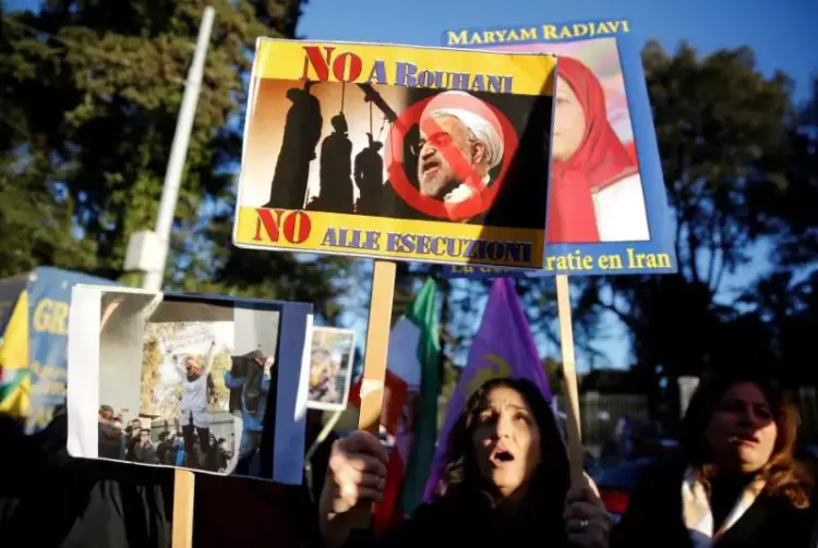  المتظاهرون في إيران يحملون لافتات مناهضة للرئيس الإيراني مكتوب عليها «لا لروحاني»