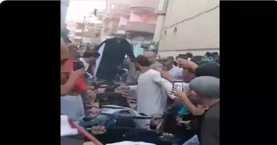 رجل يضع السيوف على رقاب المواطنين ويسير عليها بقدمه أمام المسجد (فيديو)