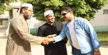 شاب مسيحي يوزع حلاوة مولد النبي على المصلين أمام مسجد في بورسعيد