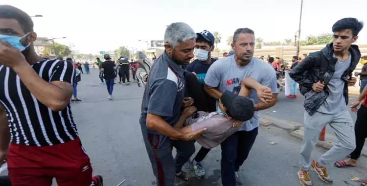  صورة متداولة لمتظاهرين بالعراق يحملون مصابا 