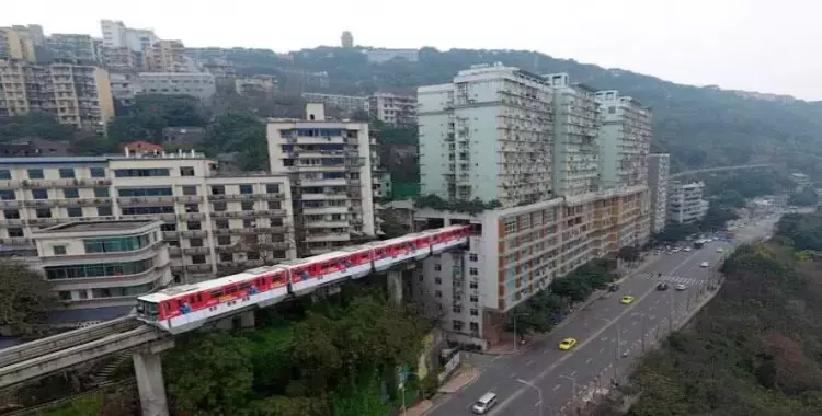  صور| لمواجهة التكدس.. قطار يخترق المنازل في الصين 